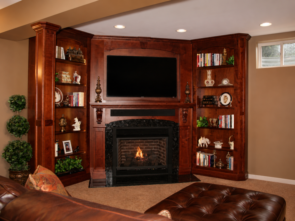 Custom cherry built-ins surrounding a fireplace with integrated television and display shelving